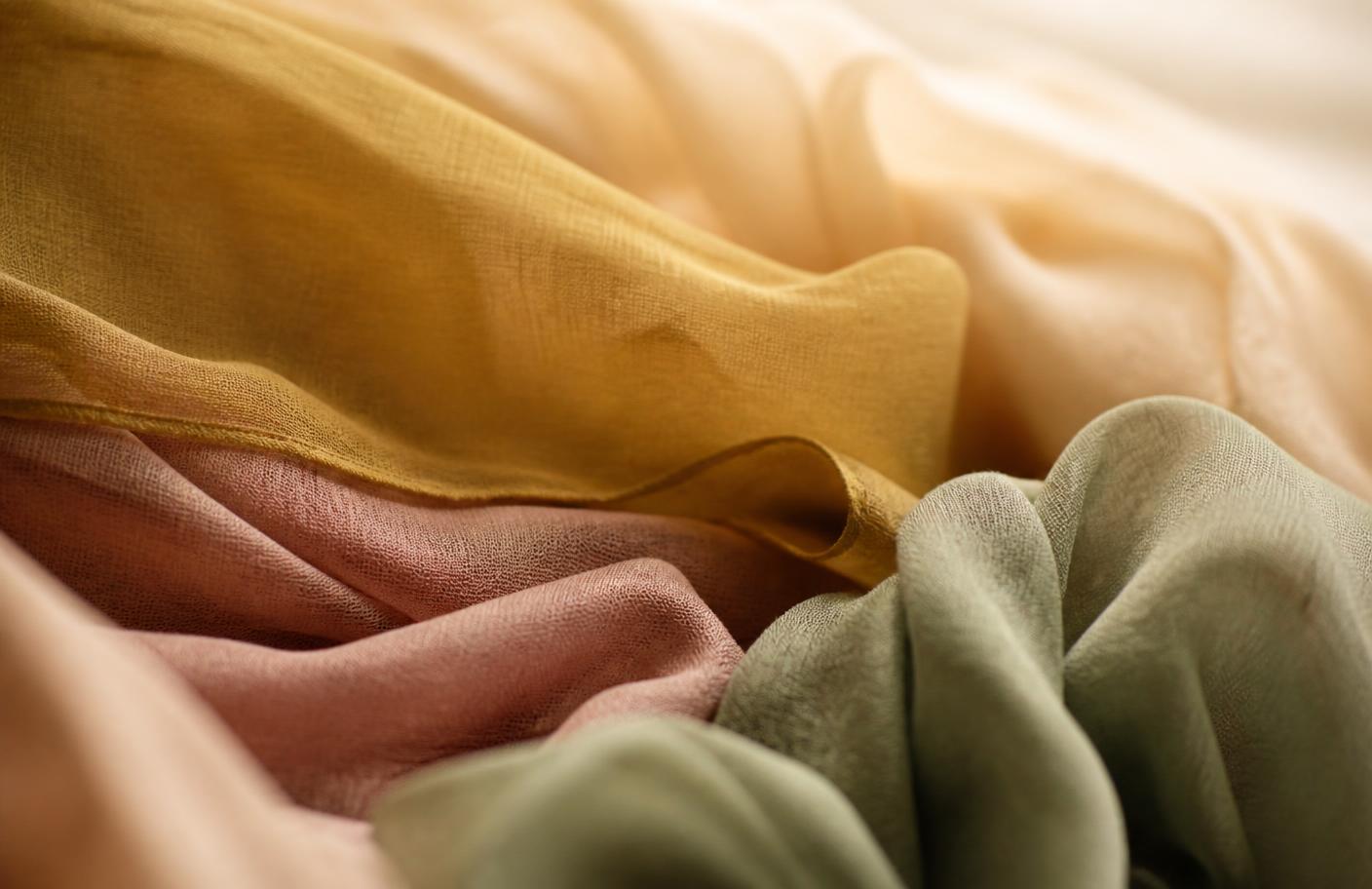 Layered mustard, dusty rose, and sage fabric in warm light